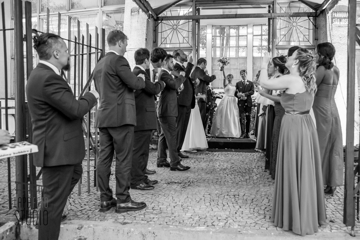 Foto em preto e branco da saída dos noivos após cerimônia de casamento na Lagoa