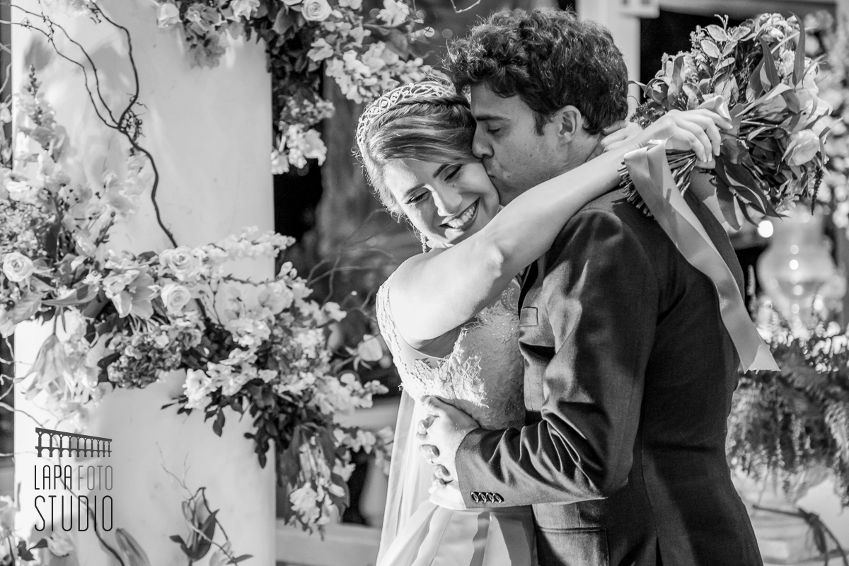 Foto em preto e branco do noivo dando um beijo na noiva durante ensaio do casal