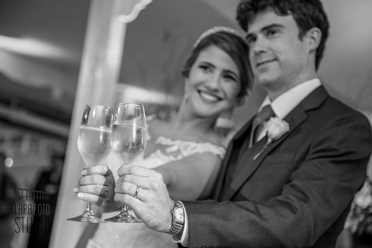 Foto em preto e branco do brinde dos noivos no dia do casamento
