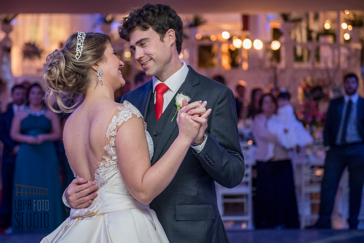 Casal troca olhares enquanto faz a primeira dança para abertura de pista de festa de casamento