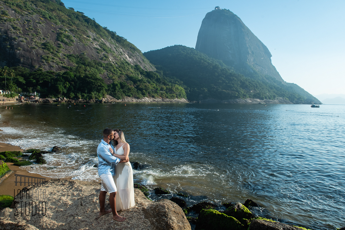 Noivos se beijando em cima da pedra com pão de açúcar ao fundo no pré wedding 