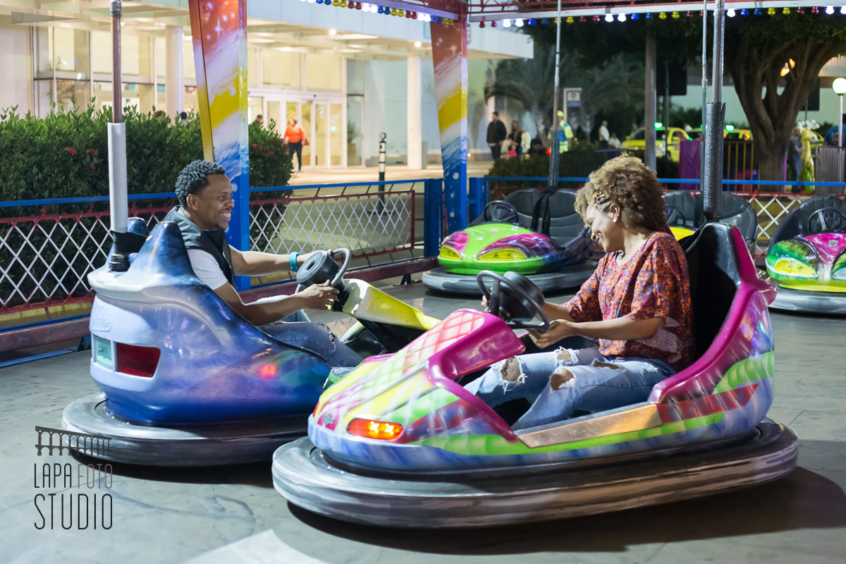 Noivos brincam no carrinho de bate bate no ensaio pré no parque