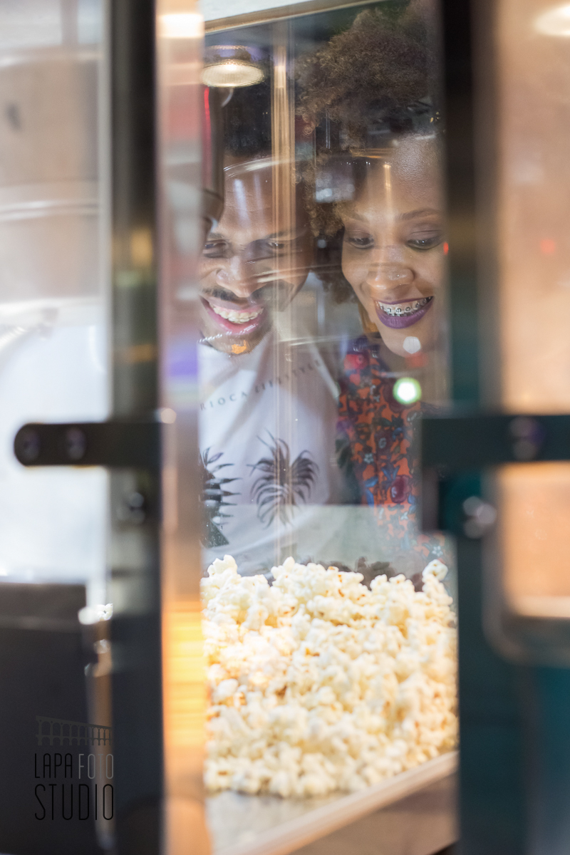 Noivos atrás da pipoqueira no ensaio pré casamento no parque de diversões
