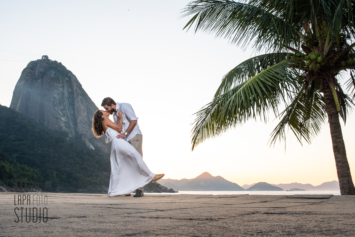 Noivos se beijam com Pão de açúcar ao fundo no calçadão da praia vermelha