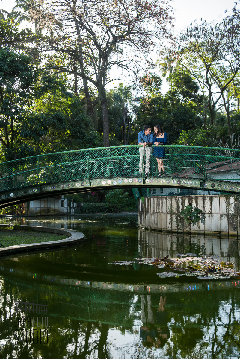 Noivos na ponta com reflexo na água do lado da Fiocruz no dia do pré wedding