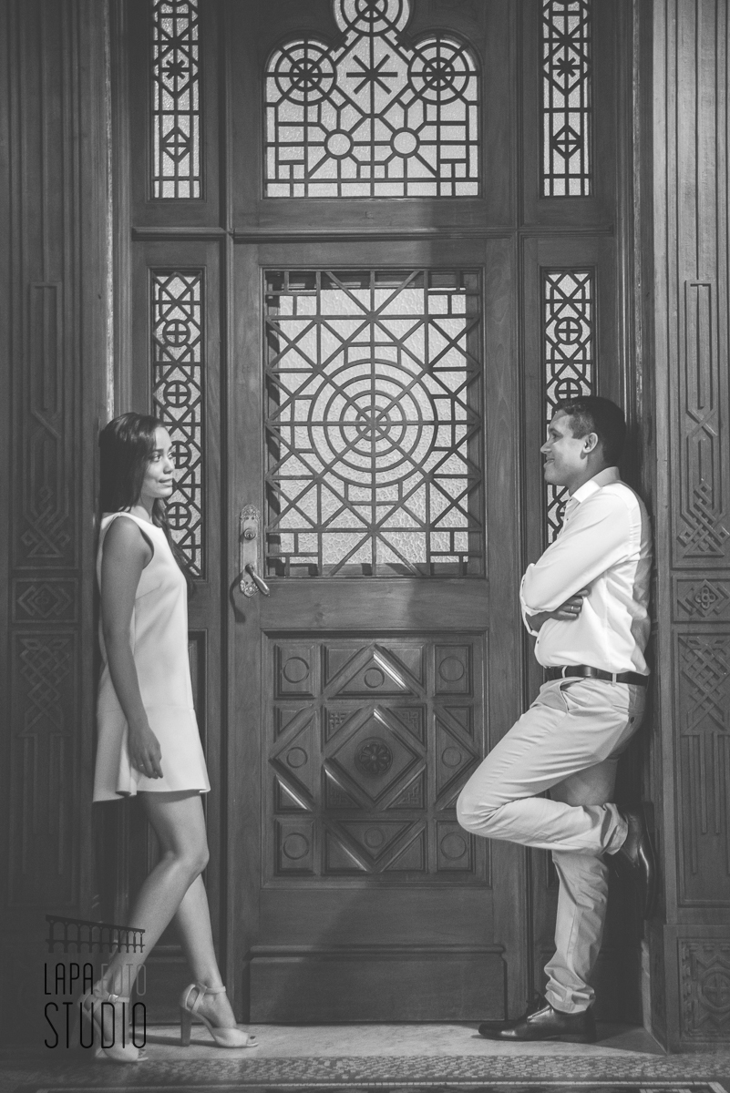 Foto em preto e branco dos noivos encostados no portal no p´re wedding da Fiocruz