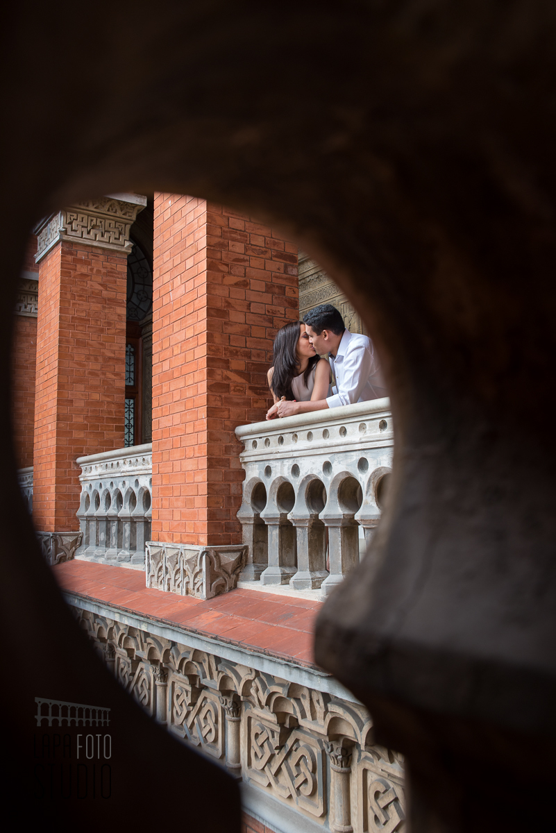 Noivos trocam um beijo no pré wedding na varanda da Fiocruz