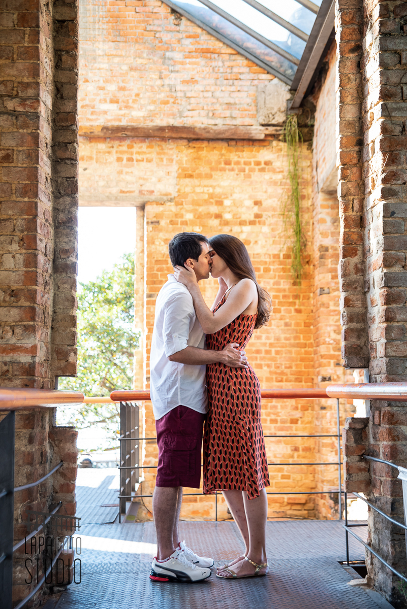 Noivos se beijam no meio das paredes de tijolinhos no pré wedding no Parque das Ruínas
