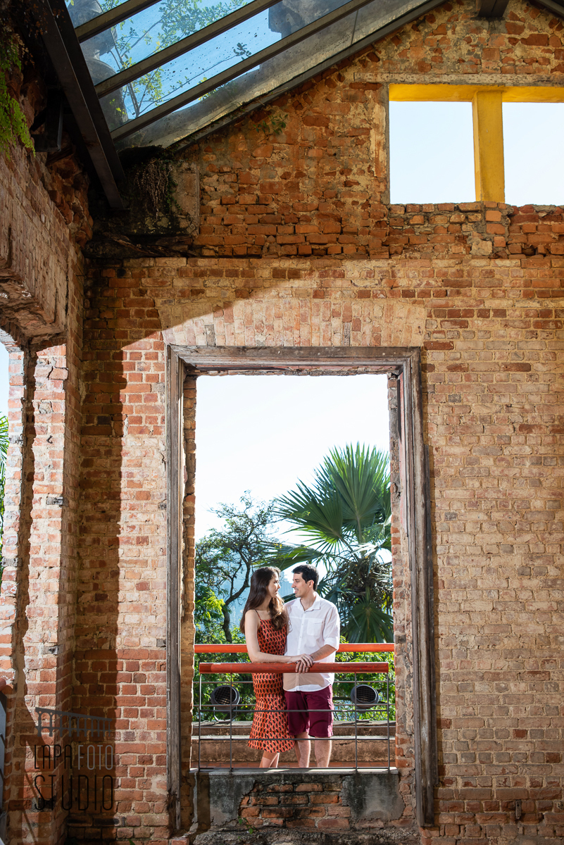 Noivos enquadrados na janela de tijolinhos do Parque das Ruínas no pré wedding