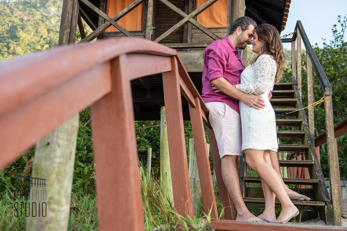 Noivos namorando na escada da casa dos salva vidas na Prainha no dia do pré wedding