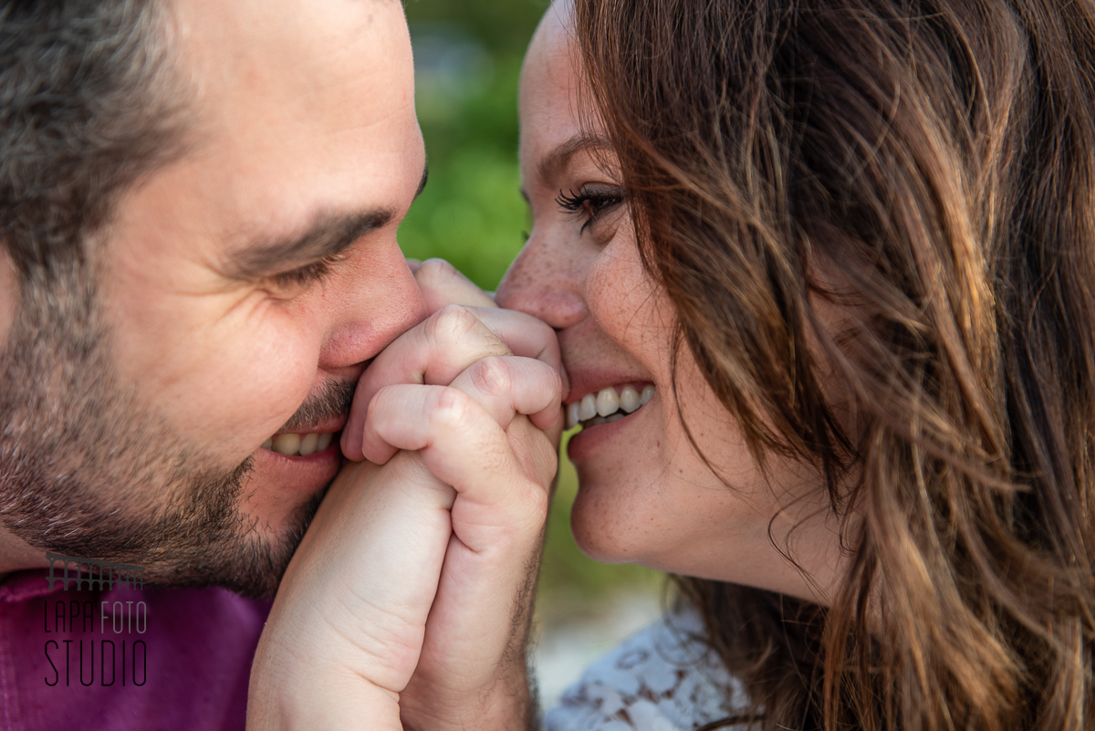 Noivos beijam suas mãos e sorriem no ensaio pré casamento na Prainha