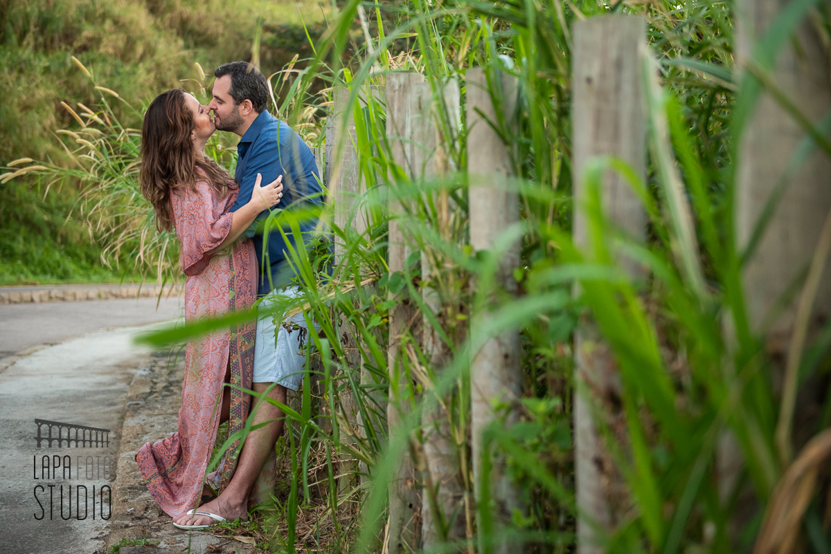 Noivos se beijam encostados na cerca de madeira no ensaio no Mirante do Roncador