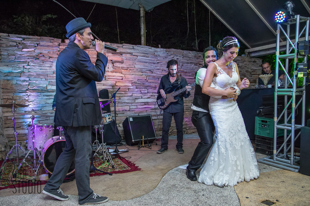 Noivos dançam no palco durante show da banda na festa de casamento