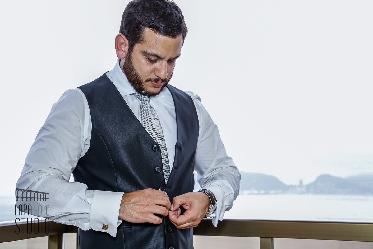 Noivo colocando o colete no seu making of