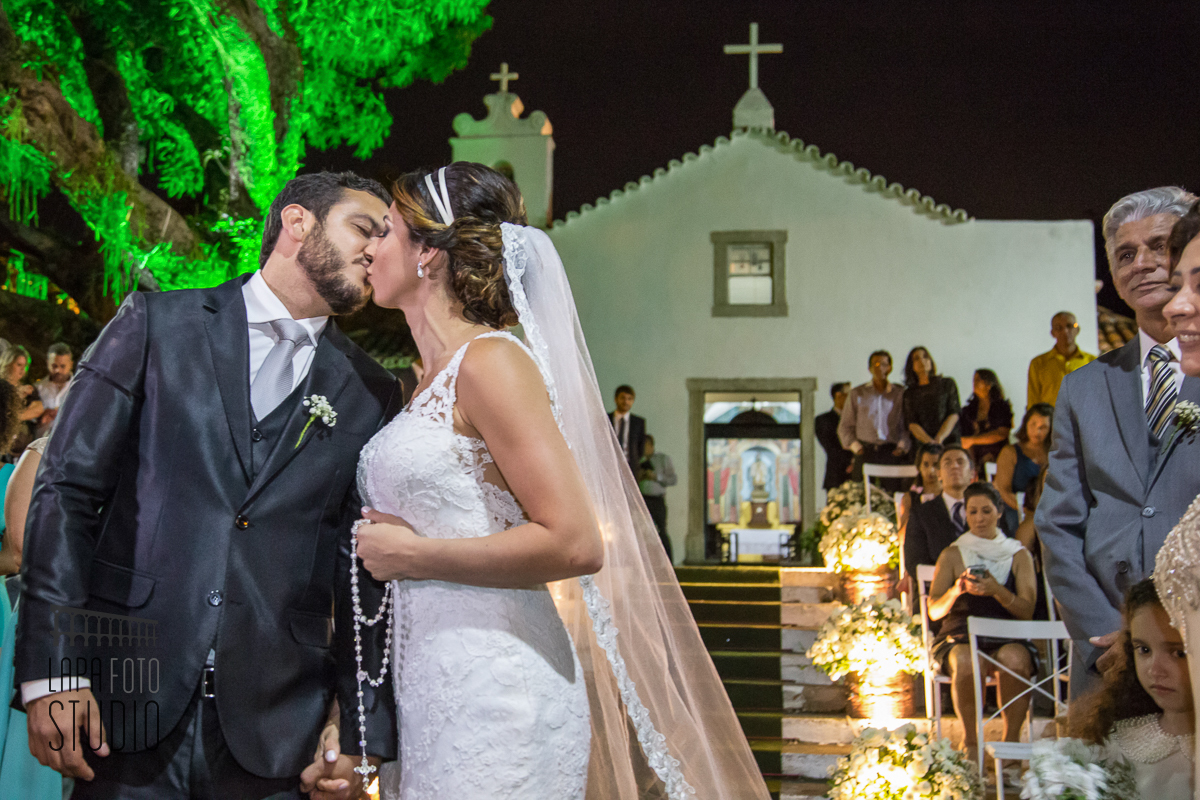 Beijo dos noivos com Paróquia de São Francisco Xavier ao fundo