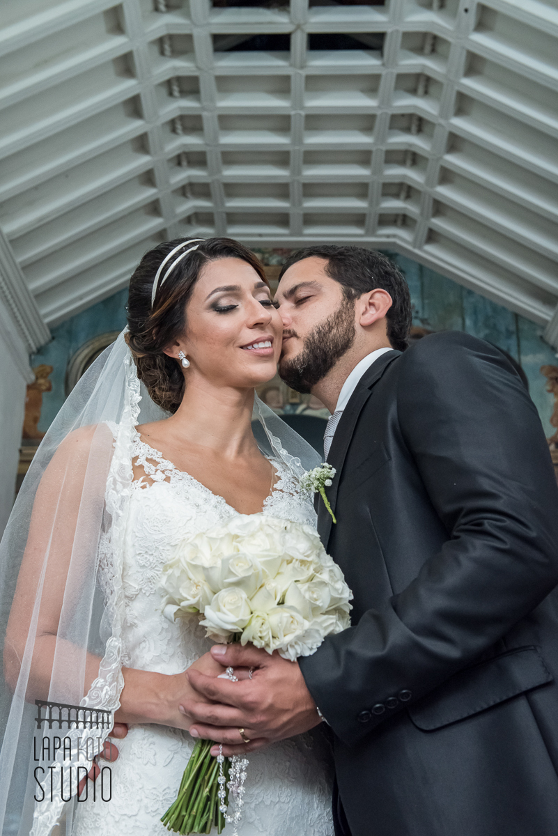 Noivo beija o rosto da noiva durante ensaio pós casamento