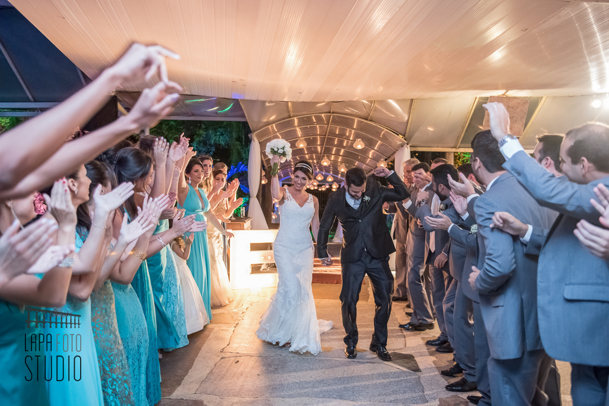 Entrada dos noivos na festa de casamento com corredor de padrinhos