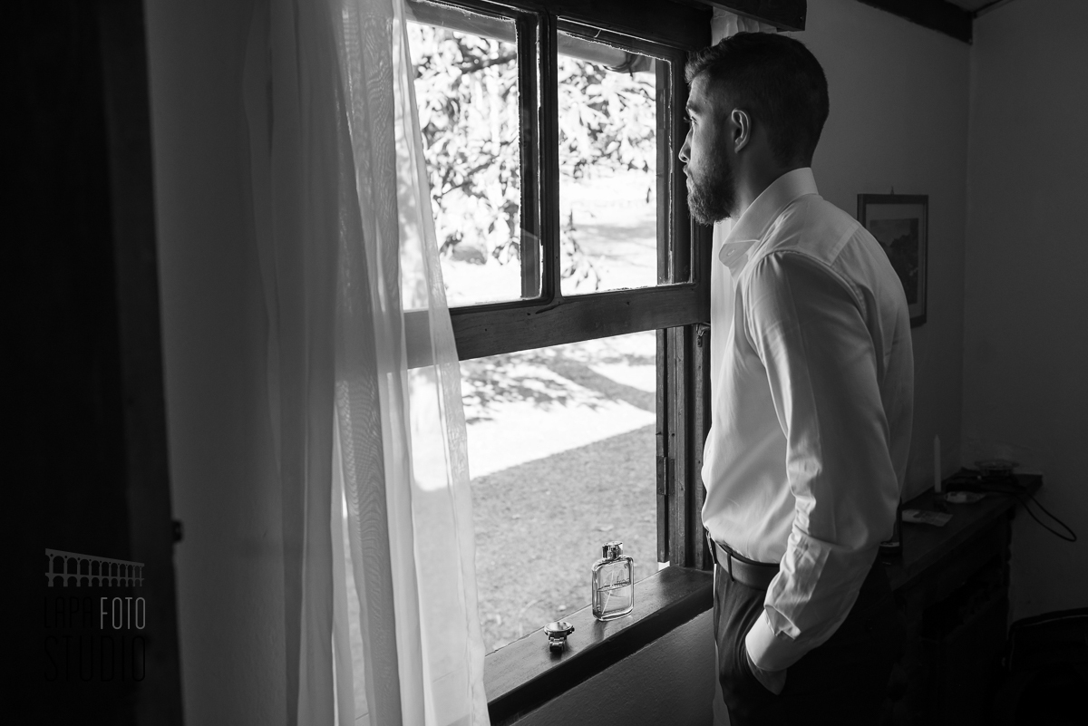 Foto em preto e branco do noivo numa janela no seu making of