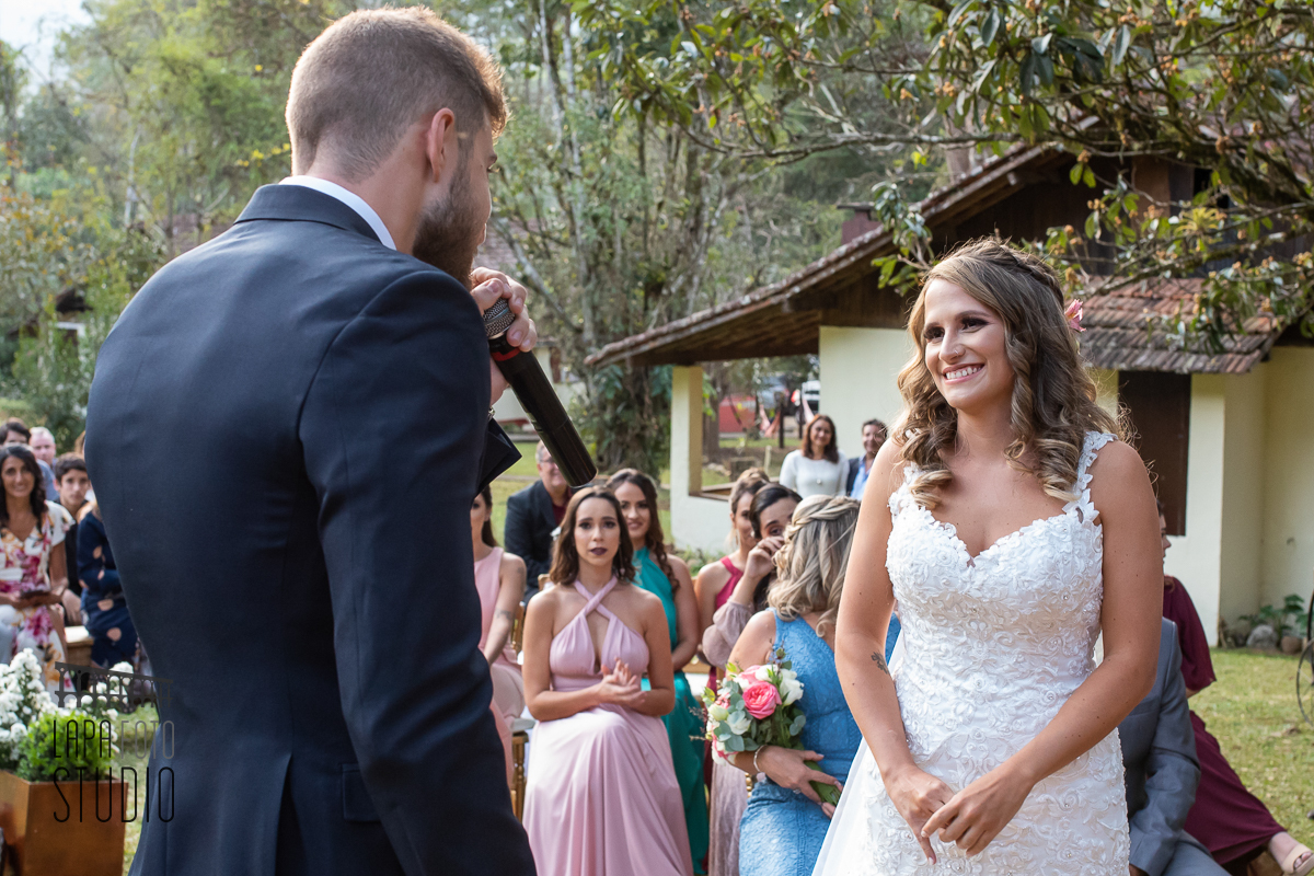 Noiva sorri para o noivo durante seus votos no casamento