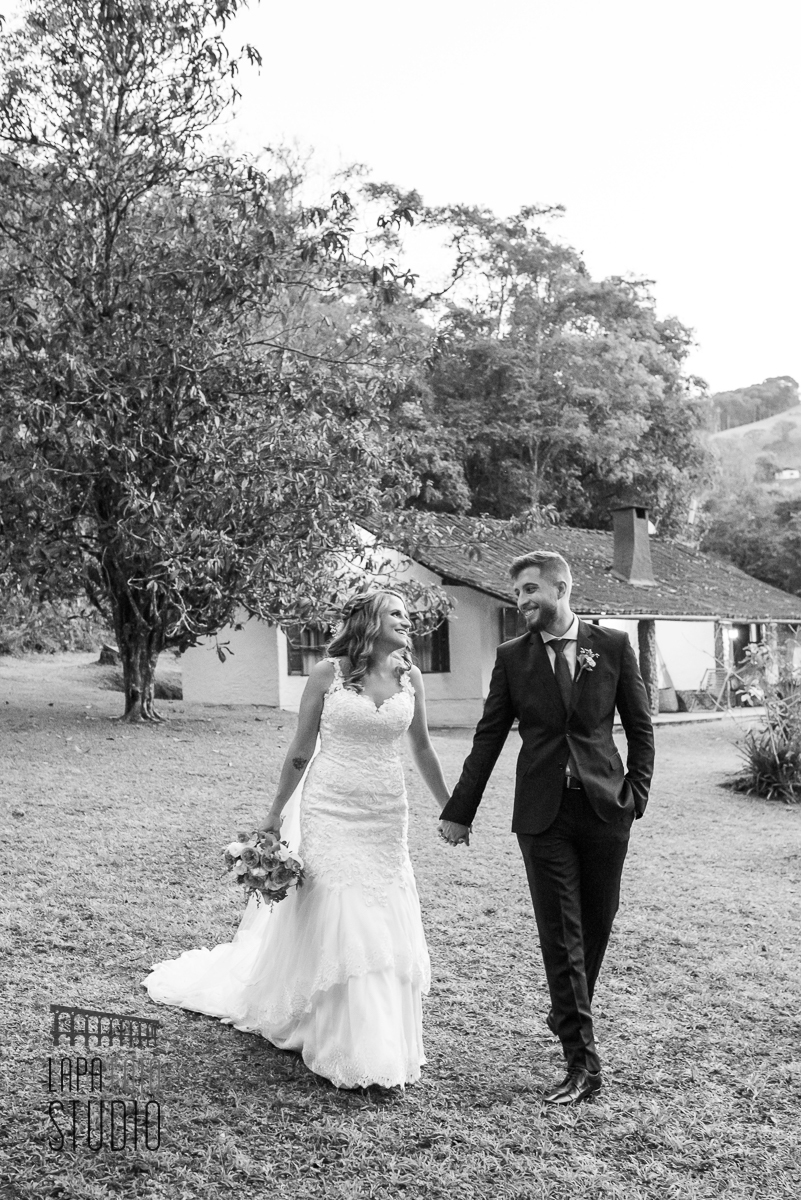 Foto em preto e branco dos noivos se olhando durante caminhada no casamento em Visconde de Mauá