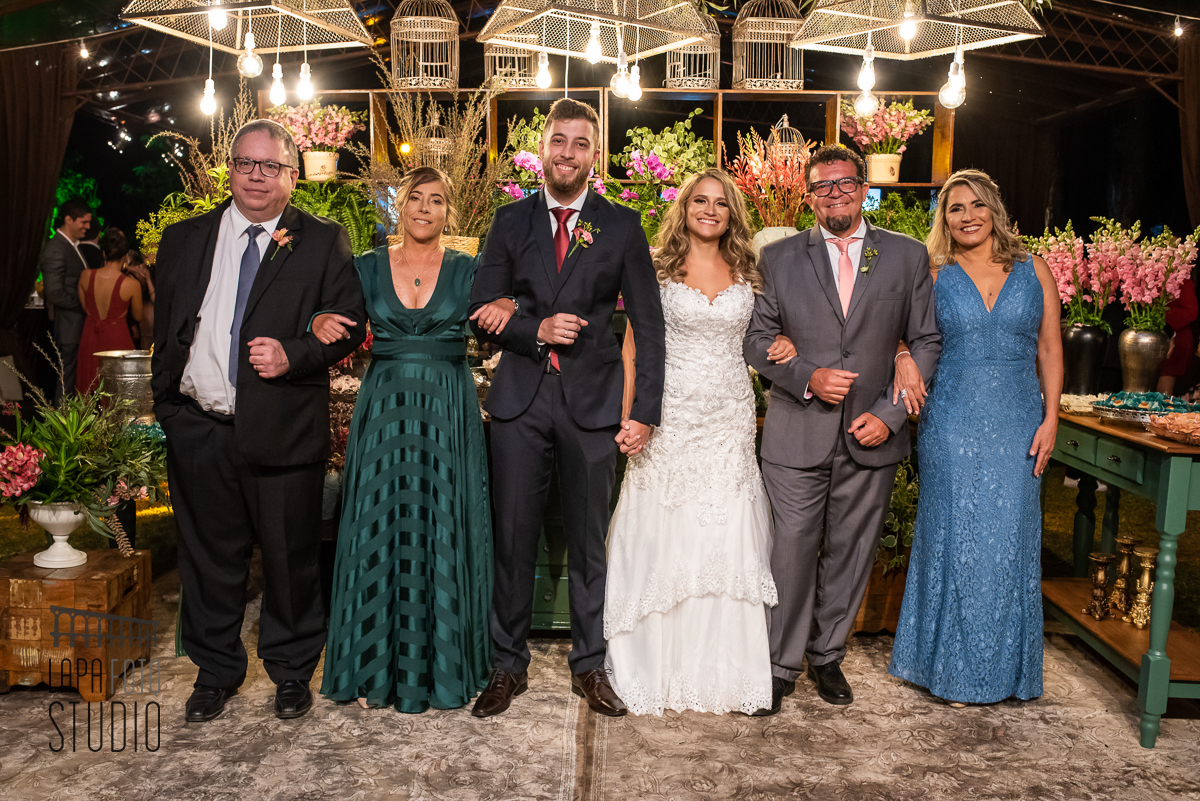Noivos com seus pais na mesa do bolo no casamento em Visconde de Mauá