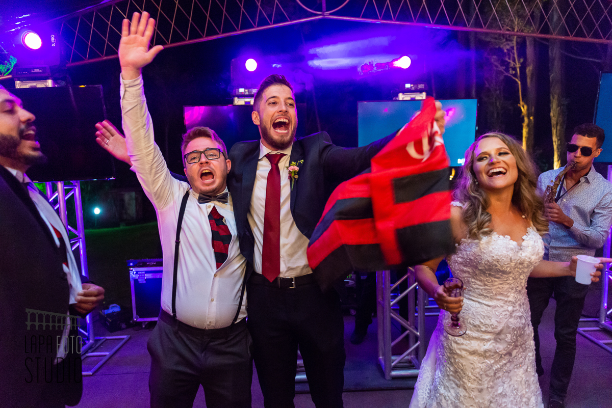 Noivo comemora com a bandeira do Flamengo junto com um padrinho na festa de casamento