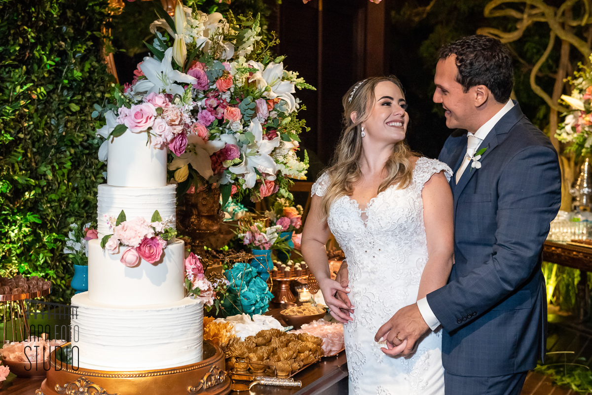 Noivos trocam olhares no bolo durante ensaio do casal no espaço Paradisus