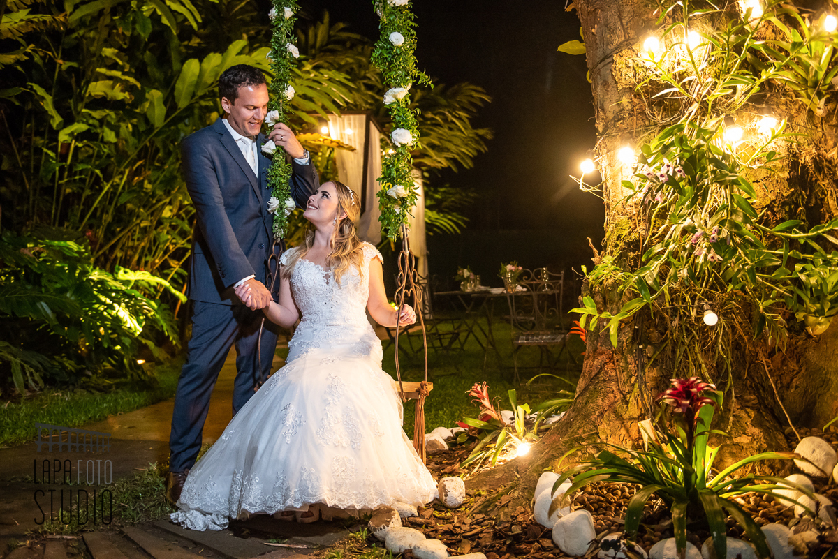 Noivos se olham de mãos dadas no balanço do espaço Paradisus