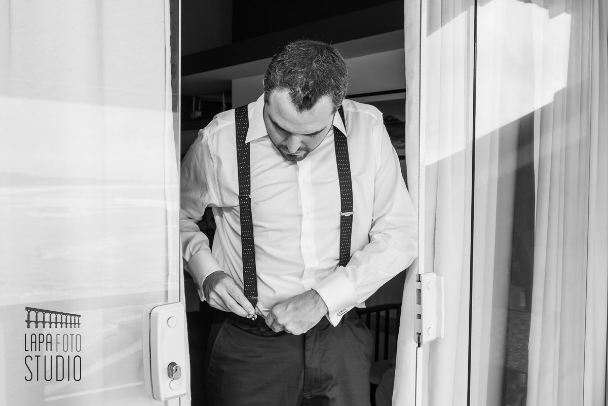 Thiago ajeita o suspensório no making of do noivo no Le Relais Marambaia