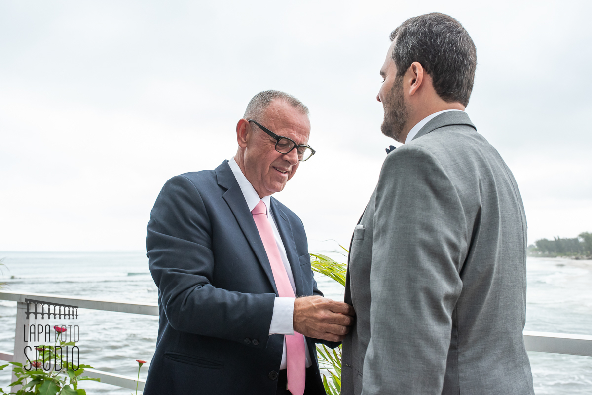 Thiago aperta a mão do seu pai no making of do noivo no Le Relais Marambaia