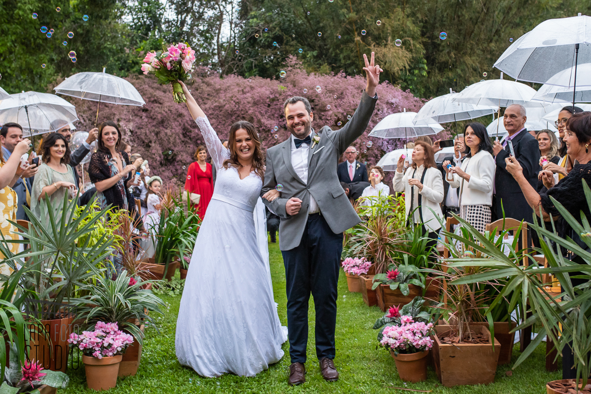 Noivos comemoram durante a saída da cerimônia de casamento no Meio do Mato Eventos