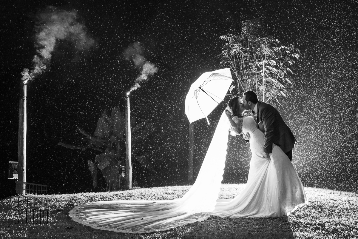 Foto em preto e branco dos noivos se beijando na chuva no Sitio Meio do Mato