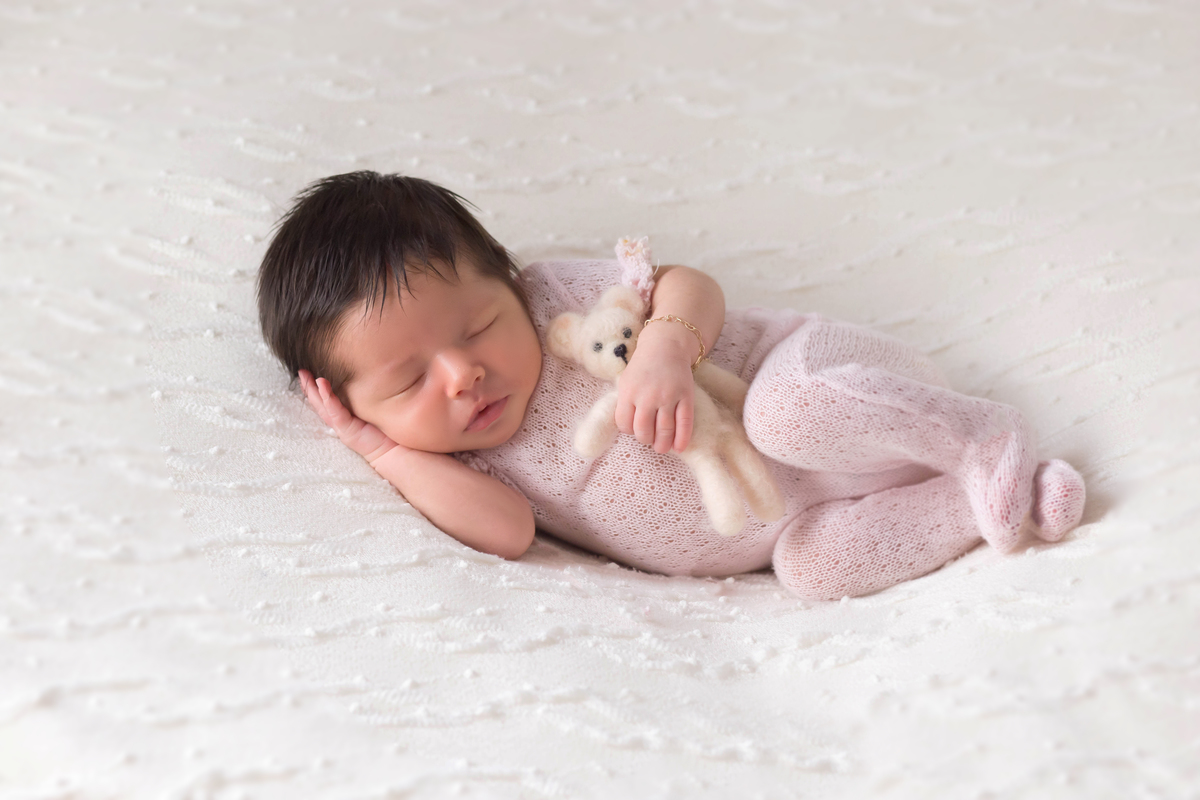 Pose de ladinho, no puff, da Helena de 18 dias em seu ensaio de newborn em Para de Minas.