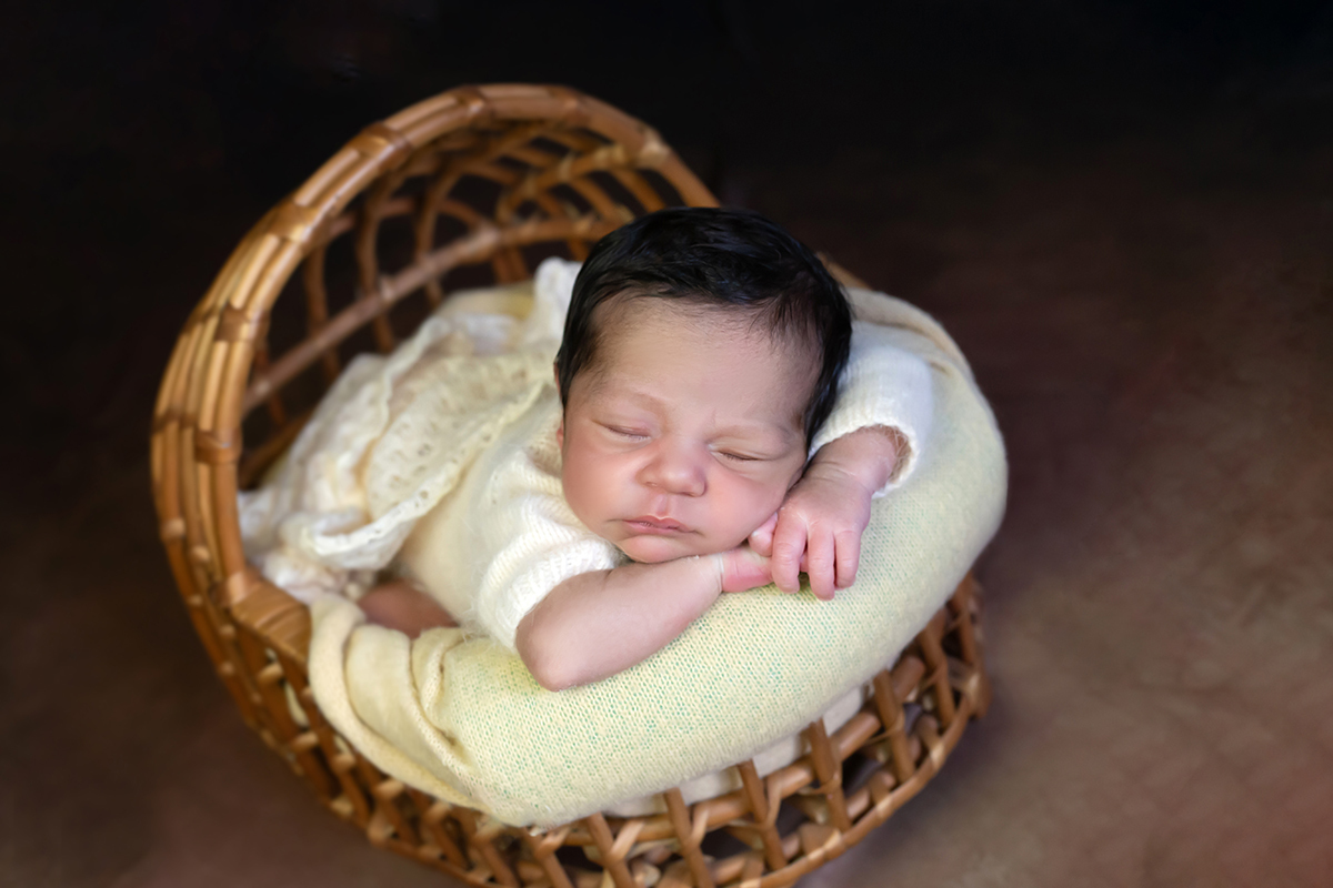 Fotos de newborn do Benjamim em Pará de Minas. Pose do bracinho no moisés.