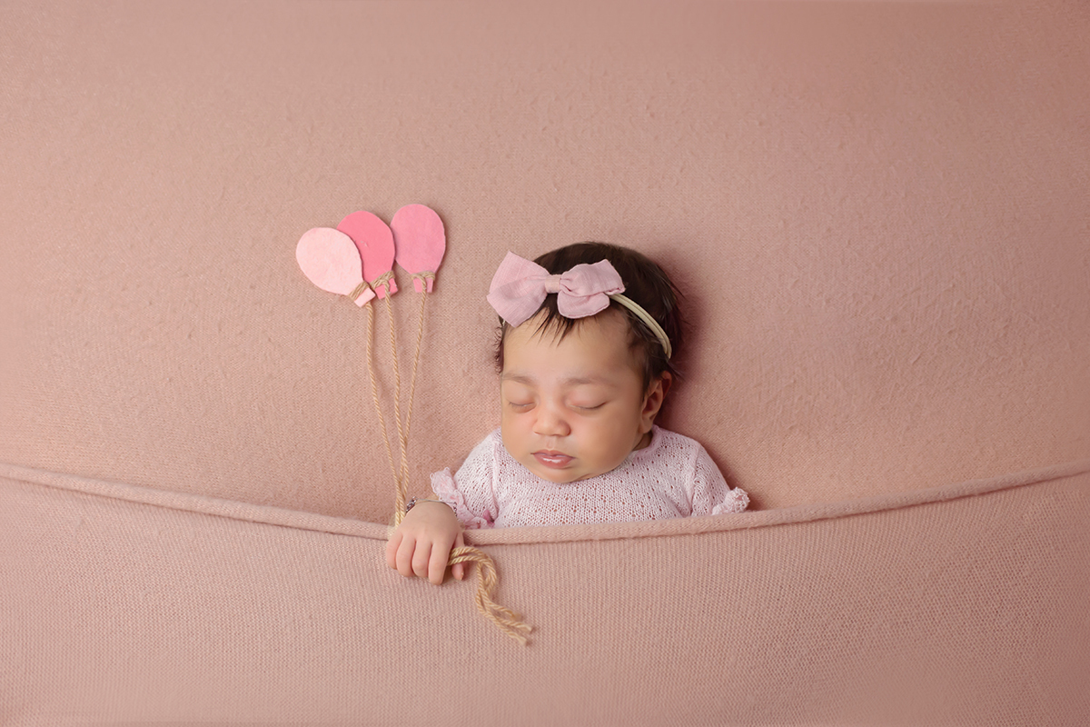 Sophia registrando seus primeiros dias de vida em seu ensaio de newborn. Pose no puff