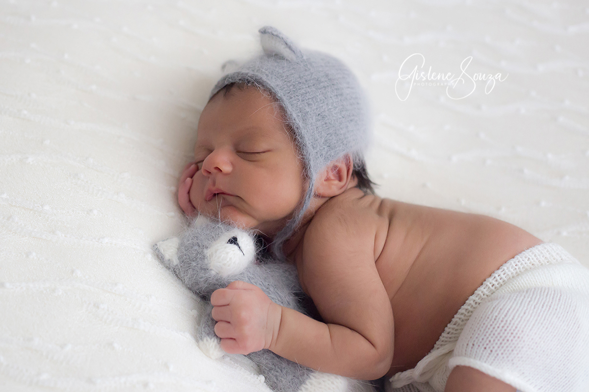 Ensaio de newborn Belo Horizonte. Pose no puff com touca de gatinho e gatinho. Composição em branco e cinza.