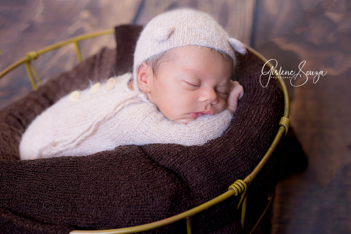 Ensaio de newborn posicionado no prop em Belo Horizonte. Foto de newborn com touca e macacão de ursinho.