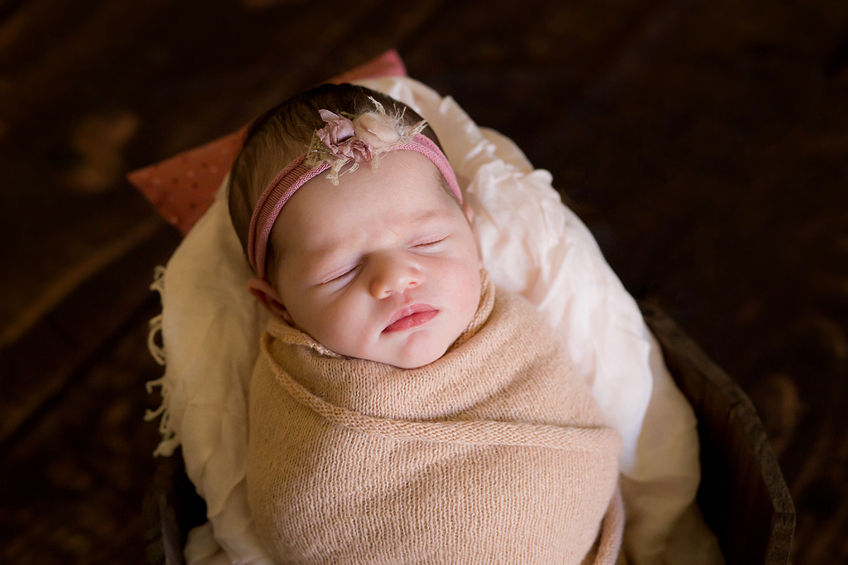 Newborn nos tons de rosa em Pará de Minas. Ensaio de newborn pose no baldinho.