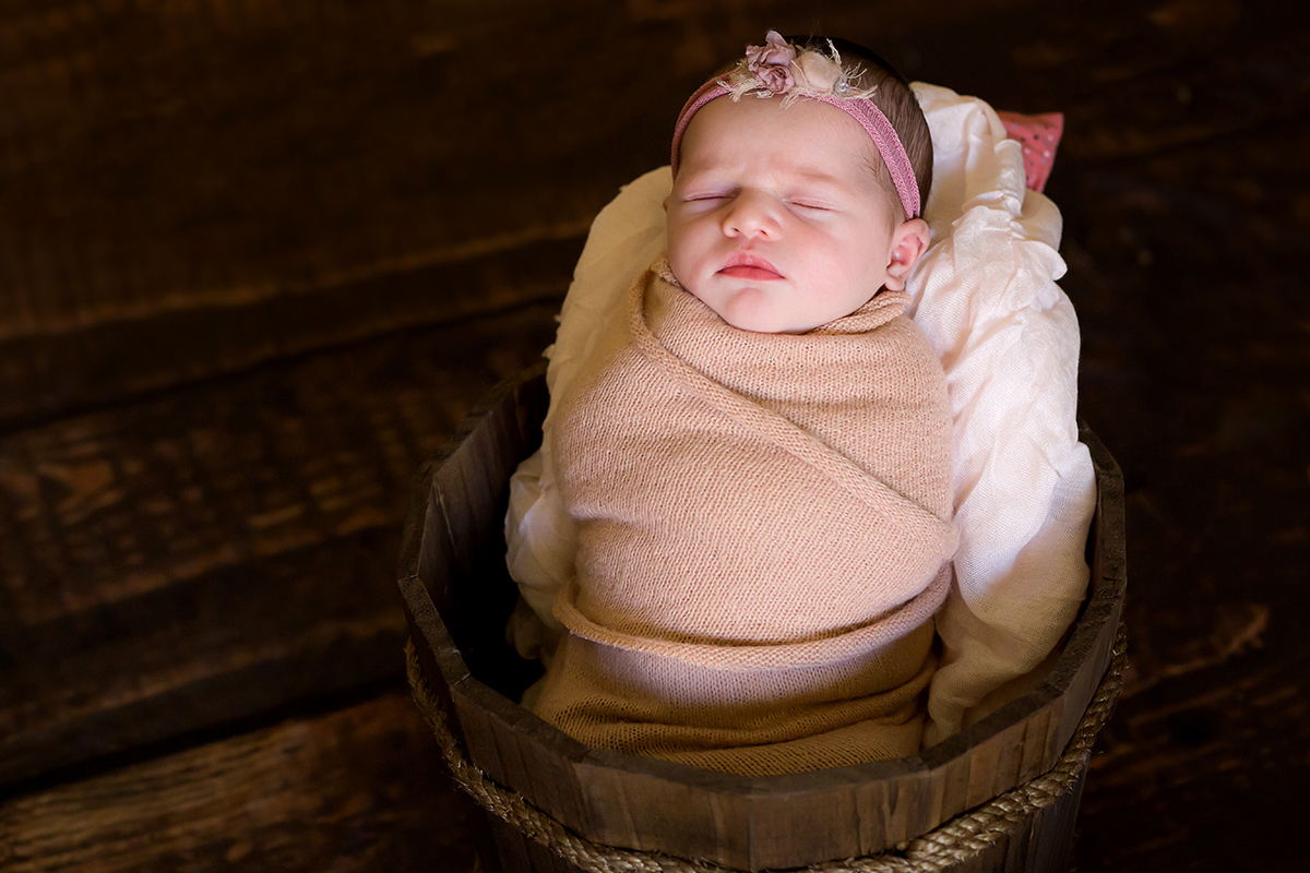 Fotografia de newborn em Pará de Minas, pose no prop e newborn enroladinho no wrap.