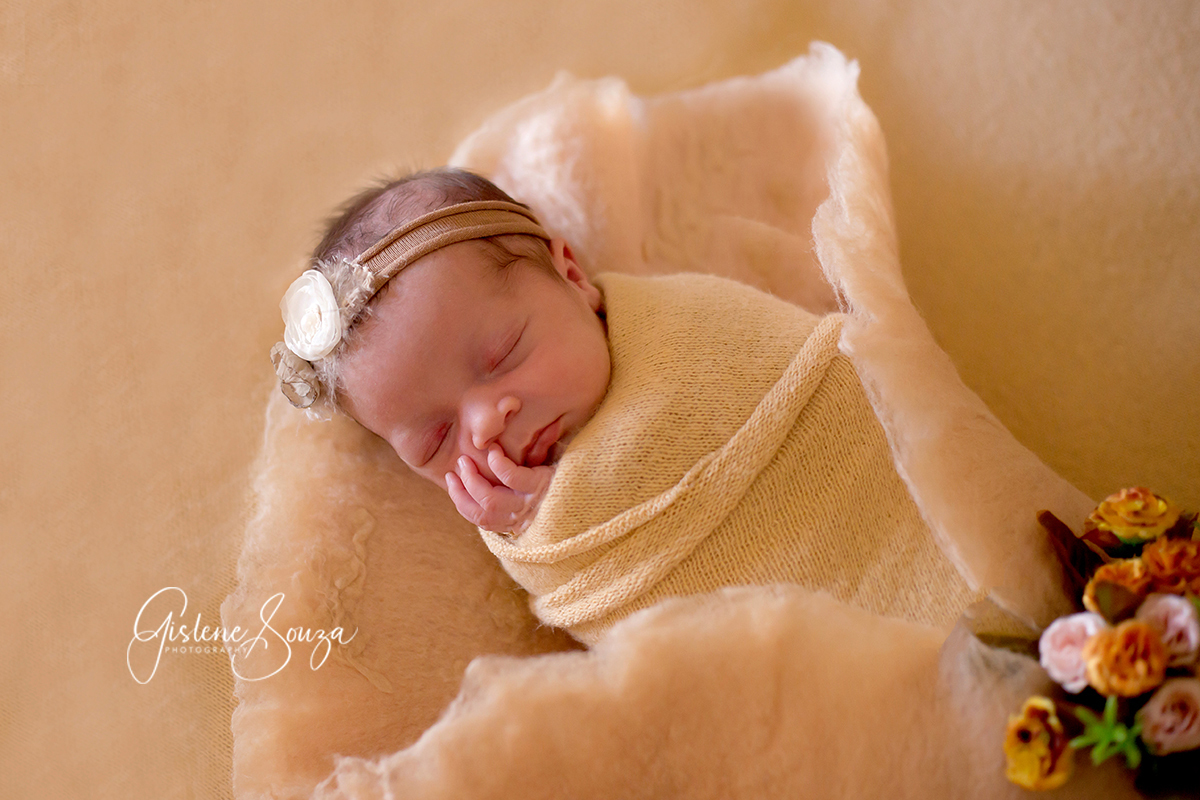 Ensaio de recém-nascido em Pará de Minas. Pose no puff na manta amarela. Composição monocromática em amarelo.