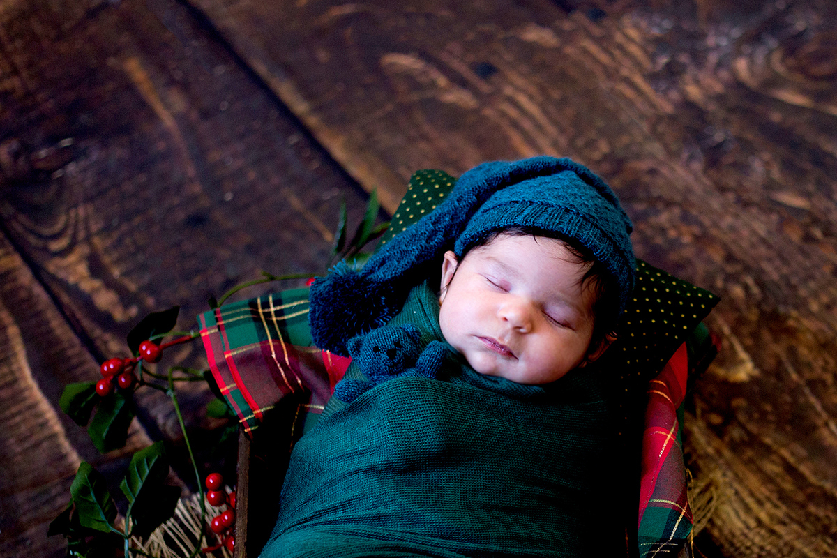 Fotografia de newborn de natal no prop com fundo de madeira. Realizado em Belo Horizonte.
