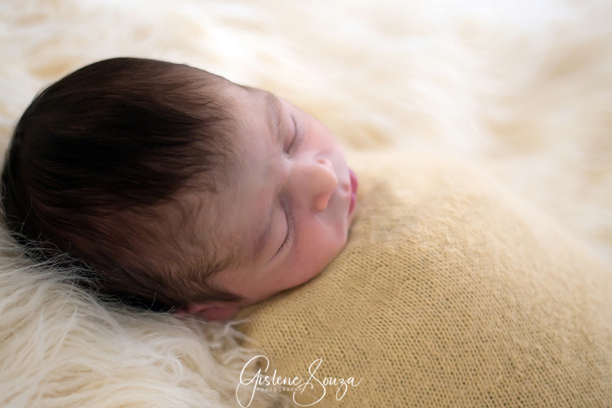 Ensaio de newborn pose no pelo sobre o puff.  Realizado em Belo Horizonte.