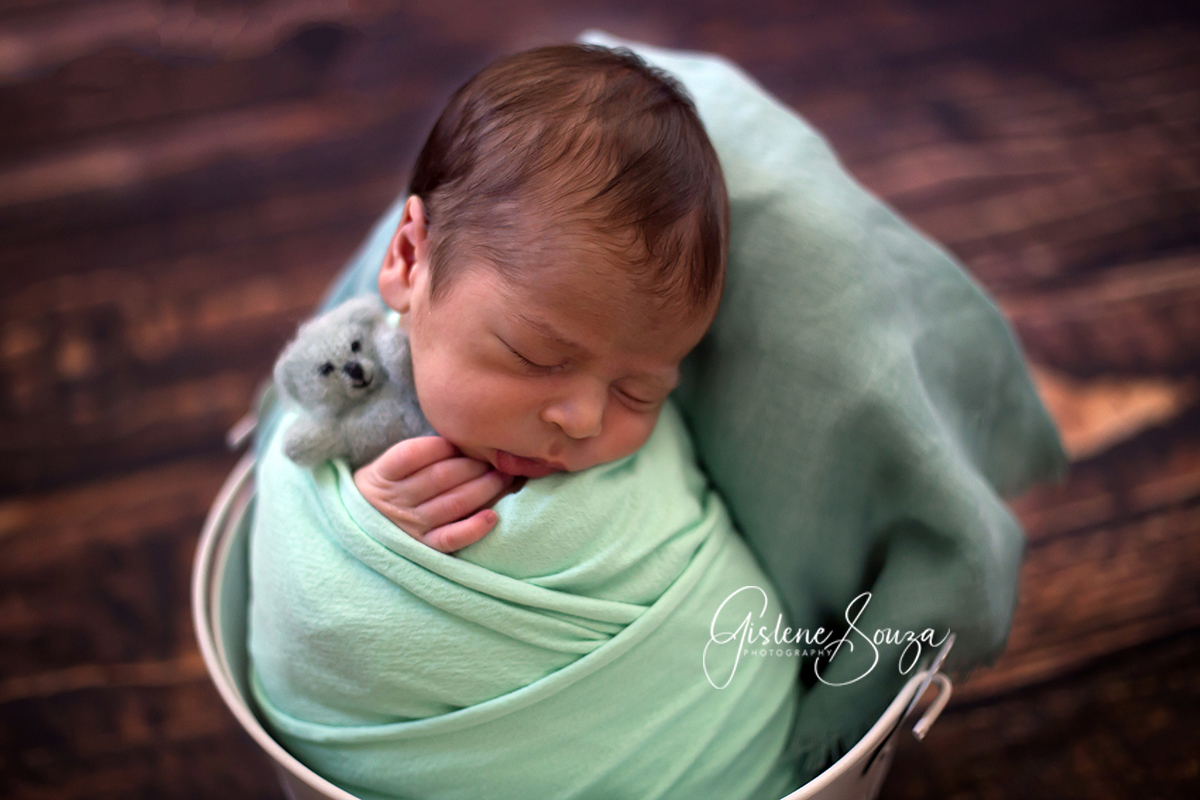 Ensaio de newborn bebe no prop baldinho. Composição monocromática em verde. Realizado em Belo Horizonte.