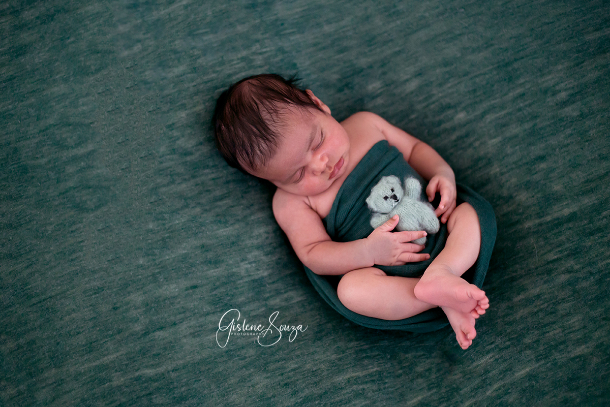 Ensaio de recém nascido, fotografia de newborn em Belo Horizonte. Pose newborn de barriguinha para cima no puff com ursinho.