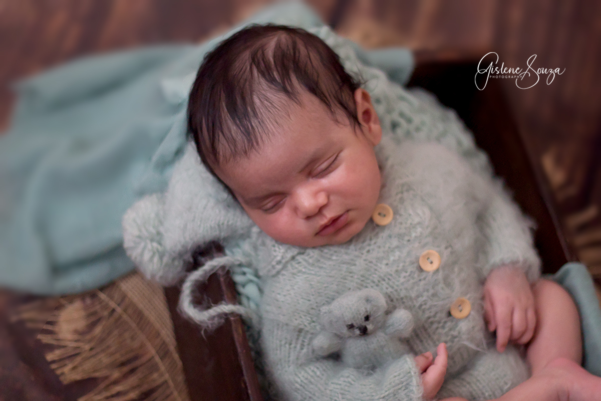 Fotografia de newborn, ensaio em Belo Horizonte. Pose de barriga para cima na caixinha. Composição monocromática.