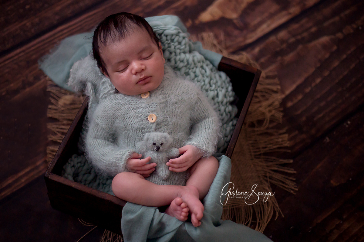 Ensaio de newborn na caixinha, realizado em Belo Horizonte. Bebê segurando ursinho.
