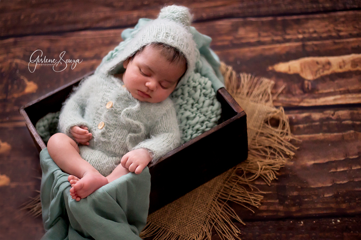 Fotografia de newborn em Belo Horizonte. Pose na caixa de madeira rustica. Composição em verde.