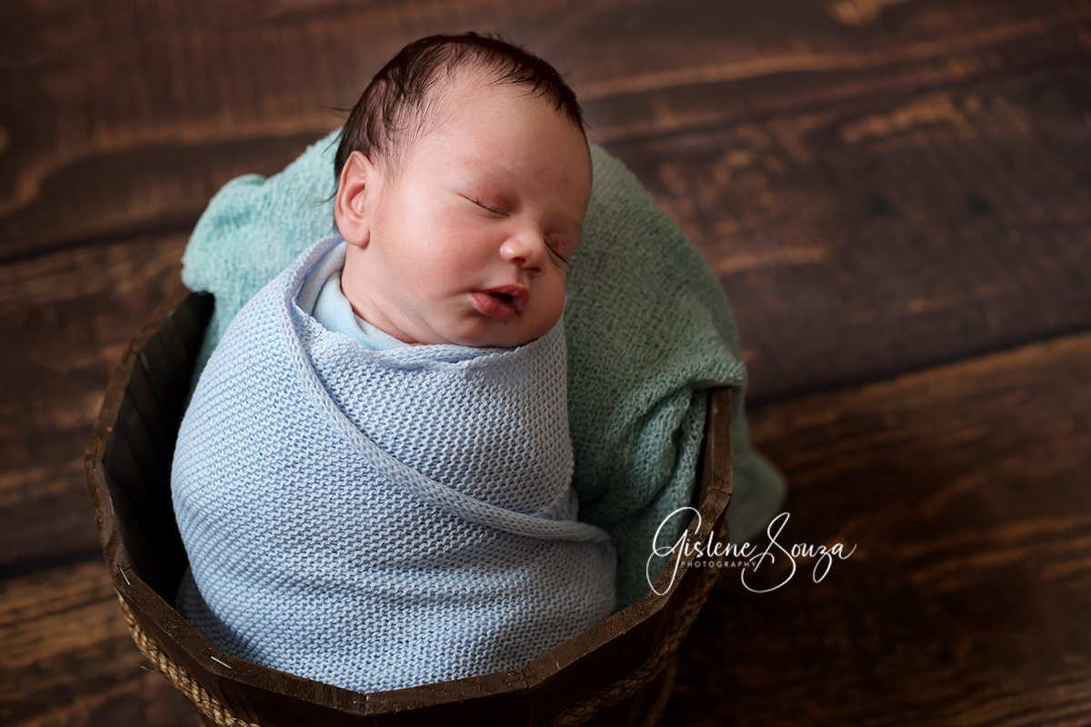 Ensaio de fotografia newborn em Belo Horizonte. Pose bebê enrolado no wrap e  no baldinho.