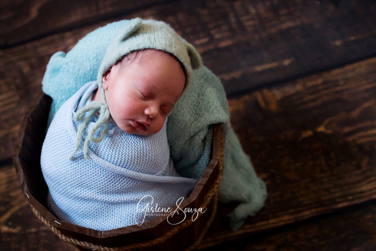 Ensaio de Newborn na cidade de Belo Horizonte. Foto em estúdio. Bebê enroladinho no wrap e no baldinho.