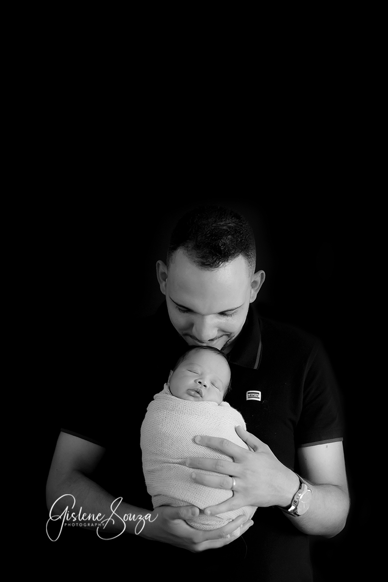 Ensaio fotografico de newborn com o pai, em Belo Horizonte. Pai segurando o bebê enroladinho no wrap.